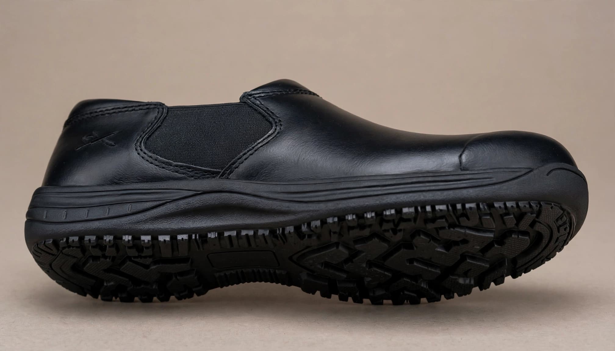 A close-up product photo of a single black restaurant work shoe on a neutral background.