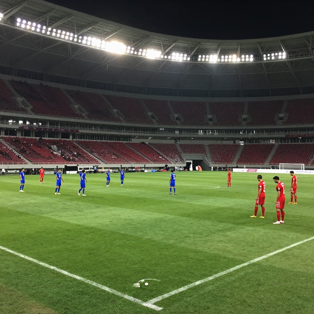 Players in blue celebrate a goal while red jersey players stand dejected on the field.