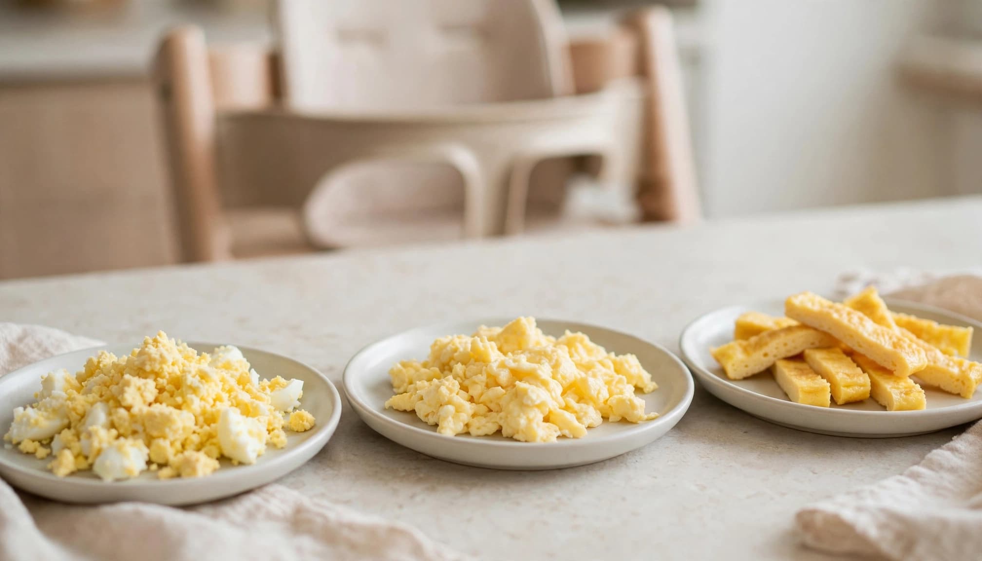 Three plates show mashed egg, soft scrambled egg, and short omelet strips.