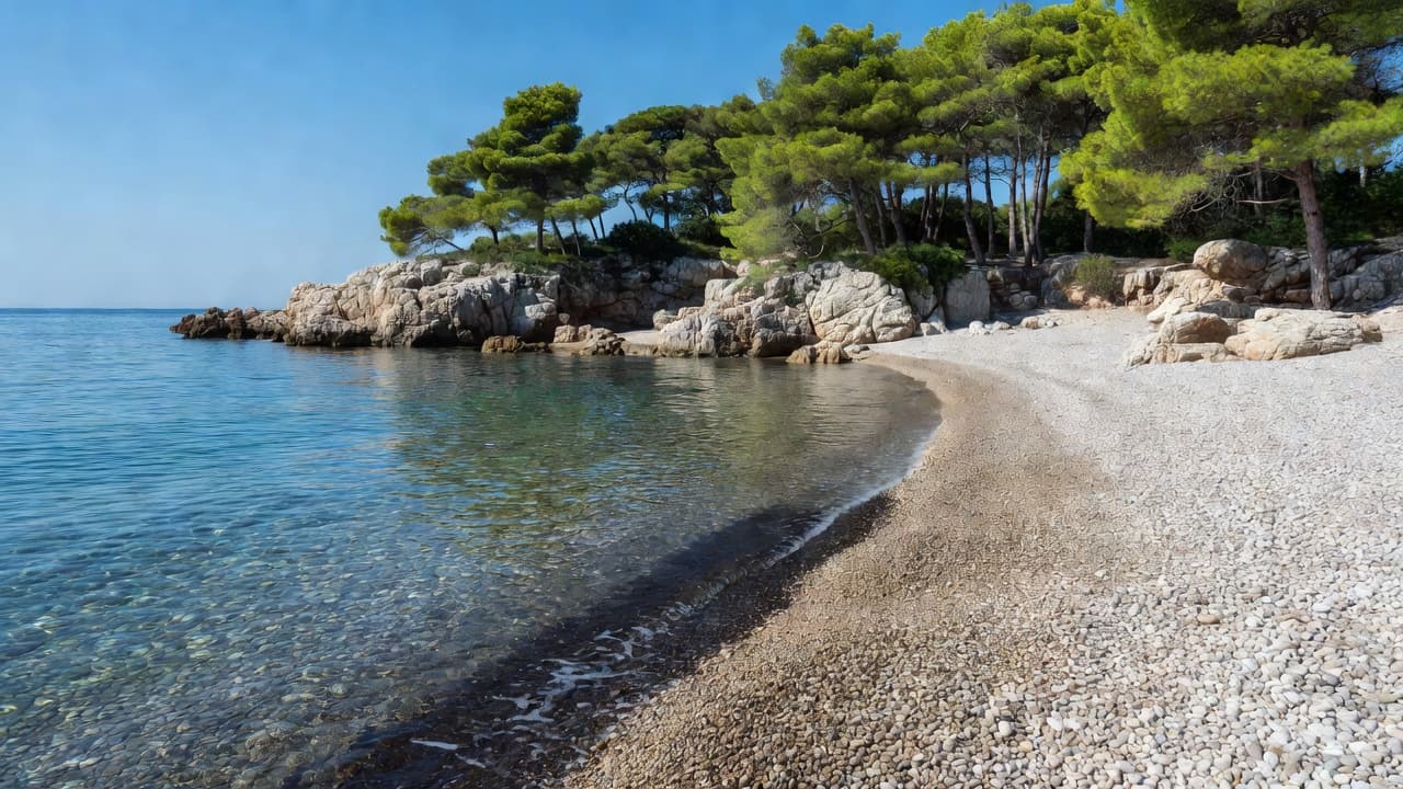 A quiet pebble cove on Hvar with clear blue Adriatic water, limestone rocks, and pine trees lining the shore in a serene shoulder-season setting.