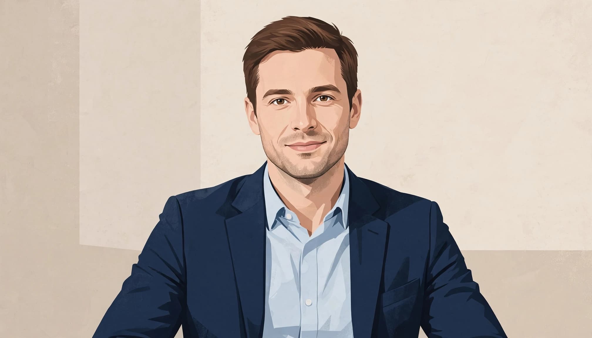 A man in a navy blazer and light blue shirt sits against a neutral wall.