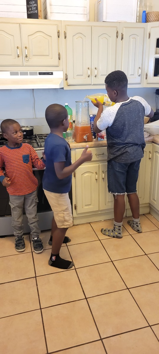 Boys experimenting with different foods and drinks in the kitchen during creative play