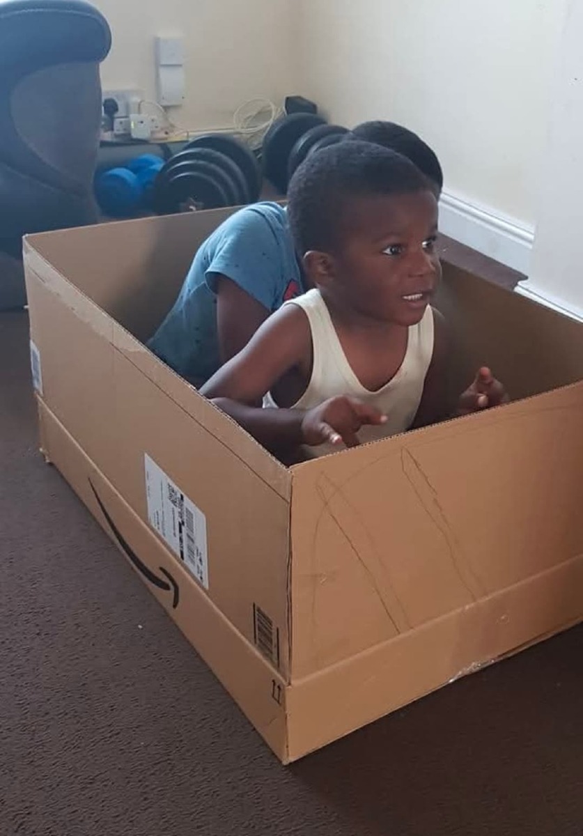 Two children playing imaginatively in a room filled with home-made forts